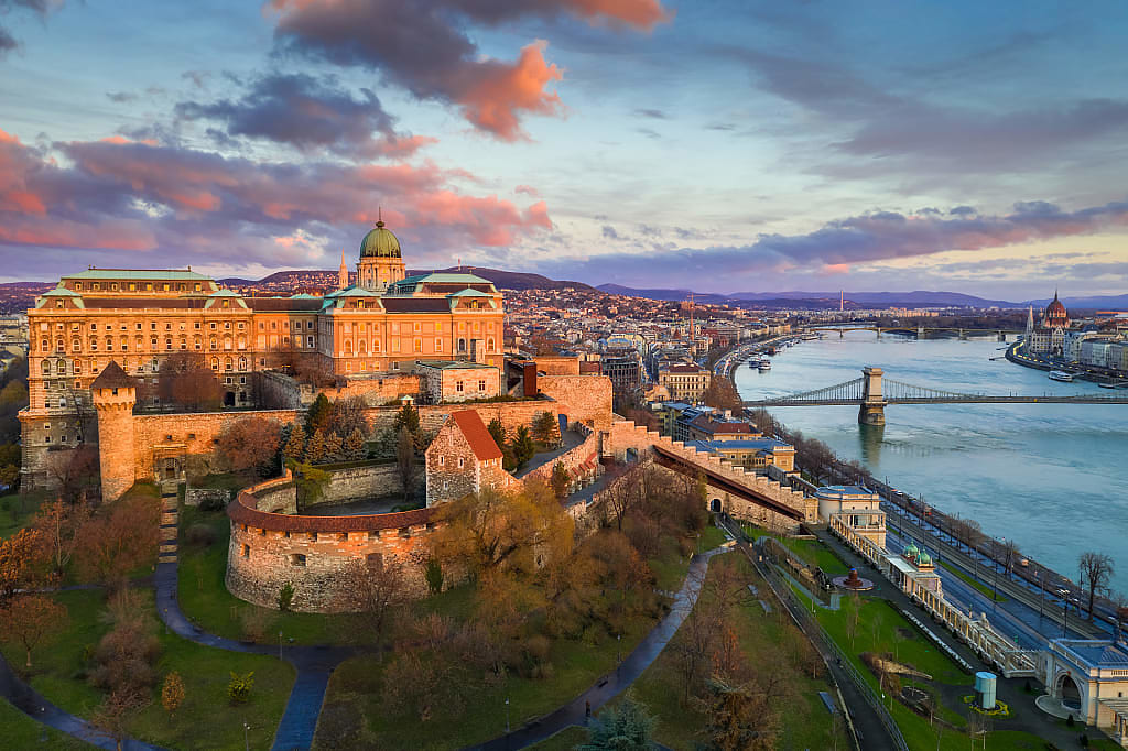 Golden sunrise and colorful clouds over Buda Castle Royal Palace with Szechenyi Chain Bridge over the Danube River in Budapest