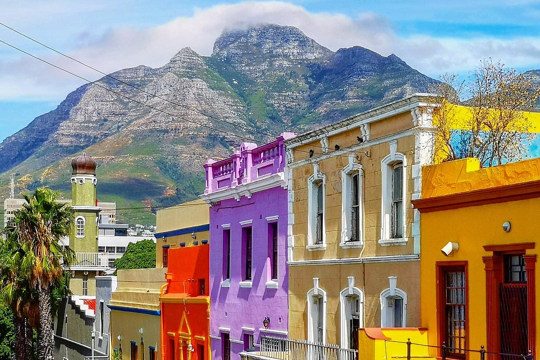 A vibrant, colorful street with Table Mountain in the background