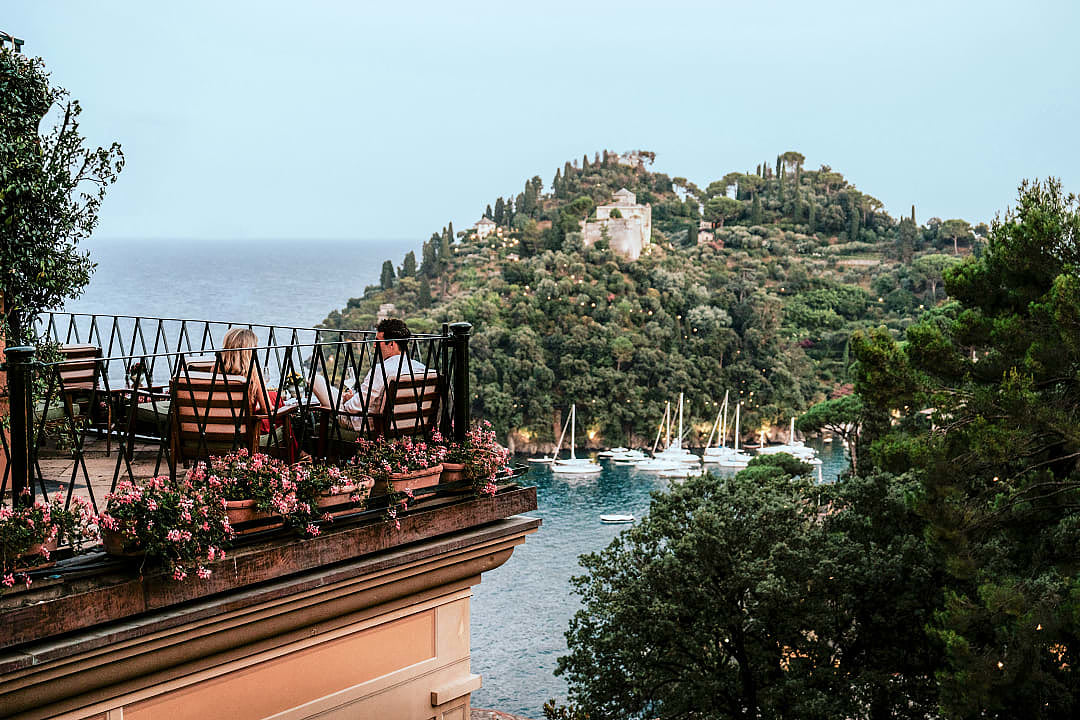 Couple enjoying scenic terrace view overlooking Portofino harbor.