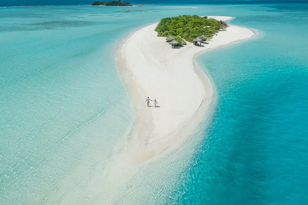 Couple on private island and secluded beach in the Maldives