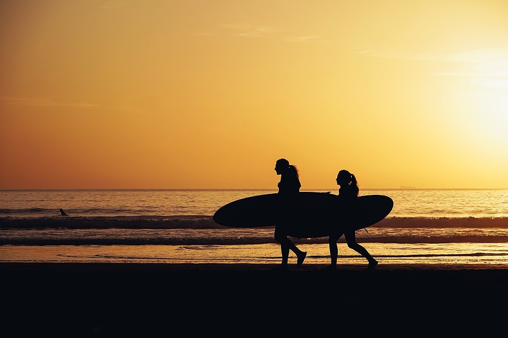Surfers enjoying beach during sunset in Taghazout