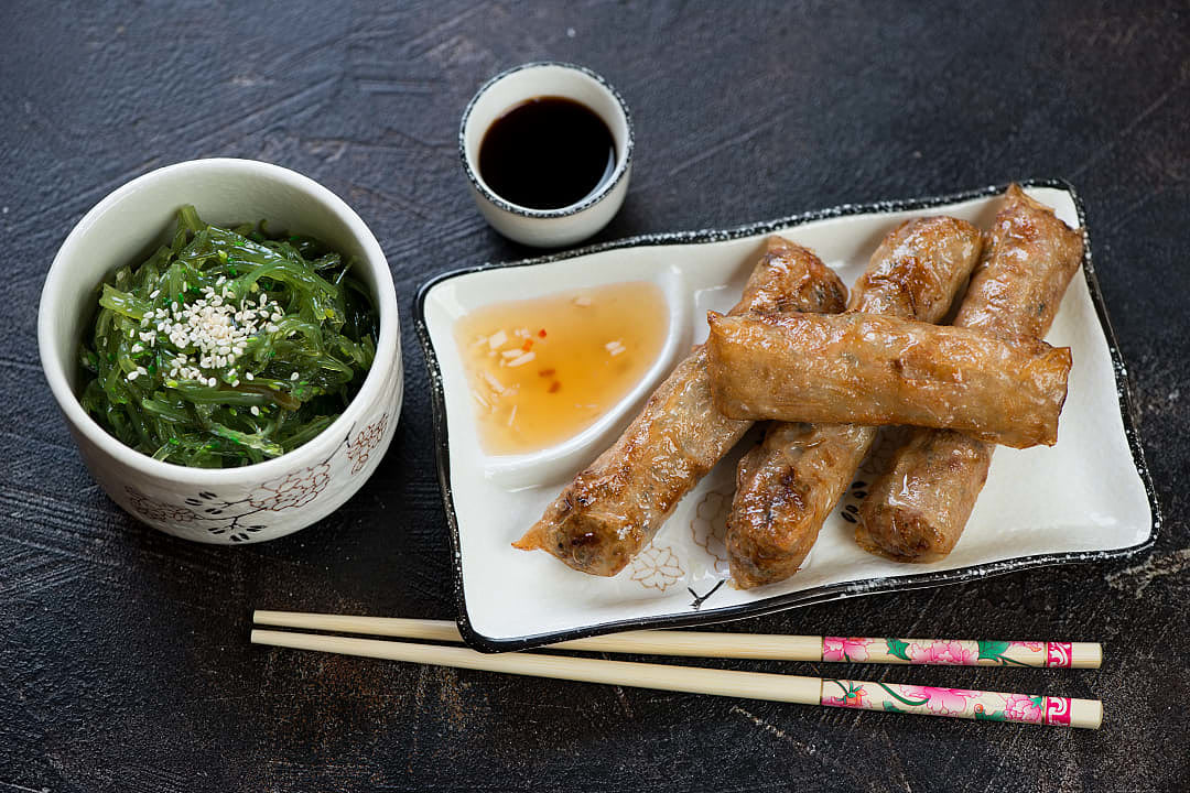 Vietnamese fried springs rolls, Nem Ran, with dipping sauce and seaweed salad