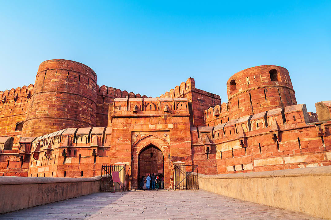 red sandstone walls and towers of historic fort glowing in warm sunlight