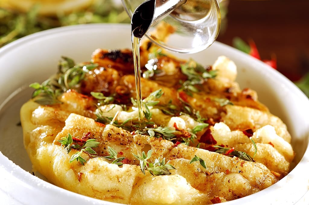 Provoleta, seasoned cheese cooked on a grill until crispy