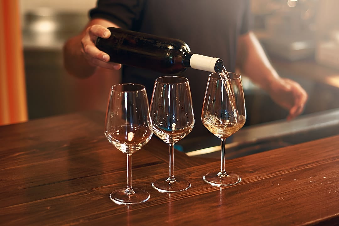 Sommelier fills wineglasses during Pinot Noir wine tasting