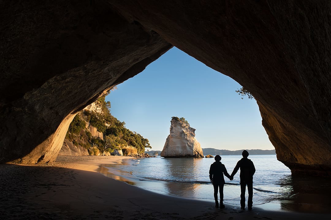 Couple at Cathedral Cove in Coromandel, New Zealand