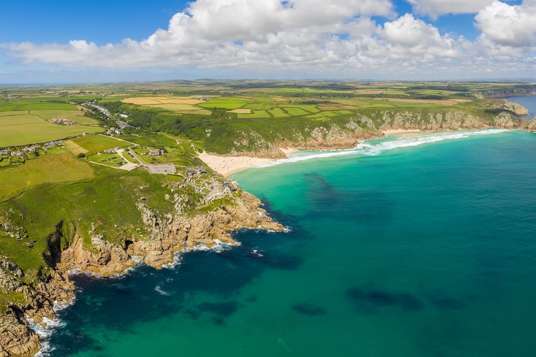 Aerial view of Porthocurno coastline with outdoor theater on the cliffs and beaches in the distance
