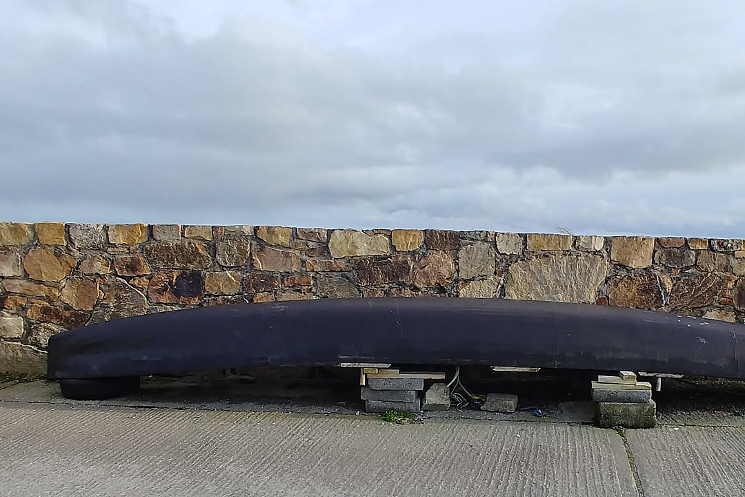 Traditional Currach boat drying in the harbor, Ireland.