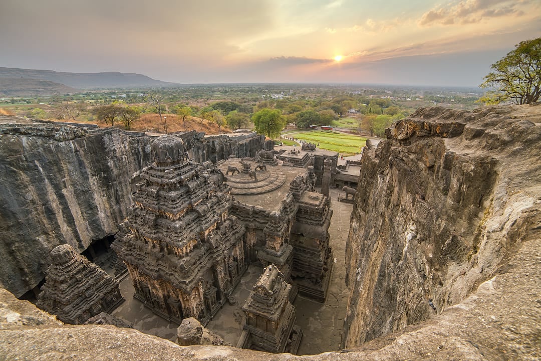 Ancient rock-cut kailasa temple complex with surrounding cliffs at sunrise