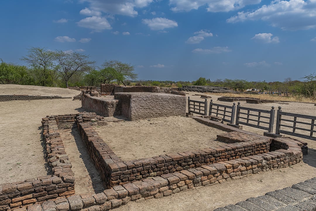 Ancient brick ruins of Indus Valley settlement under blue sky.