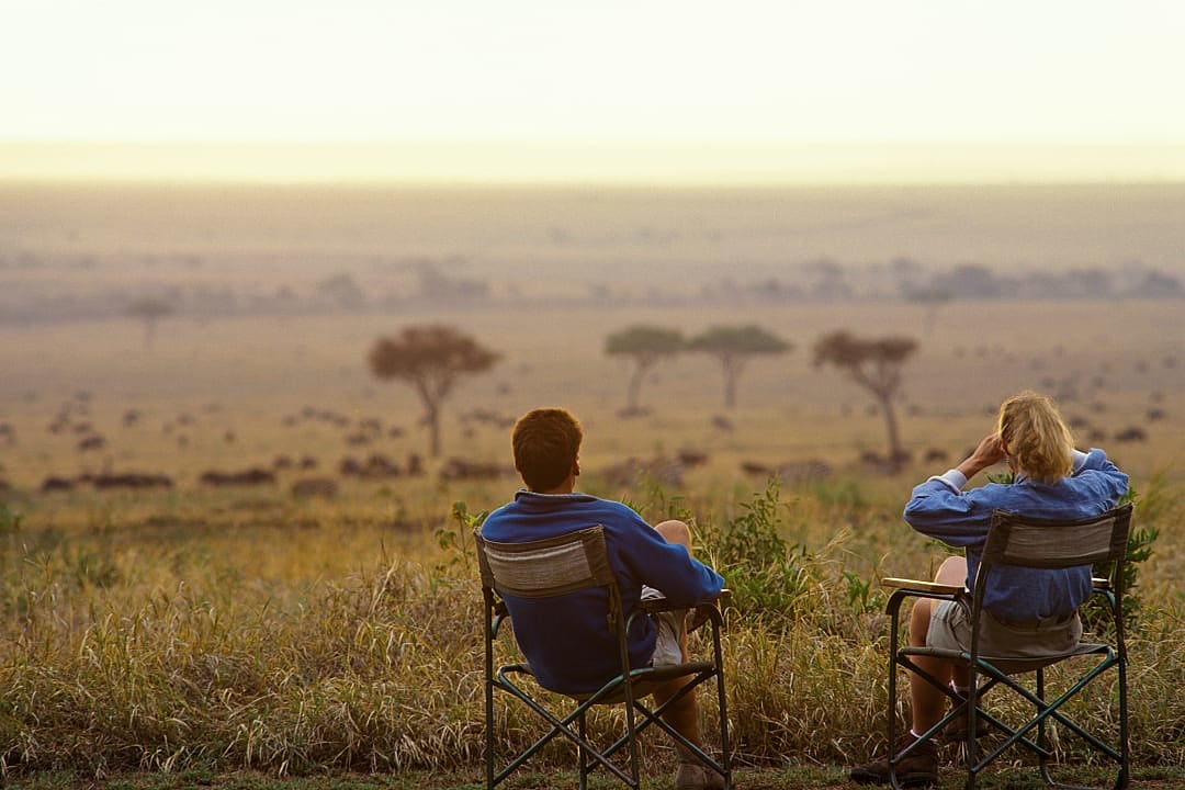 Couple on viewing wildlife on the savannah in Keyna