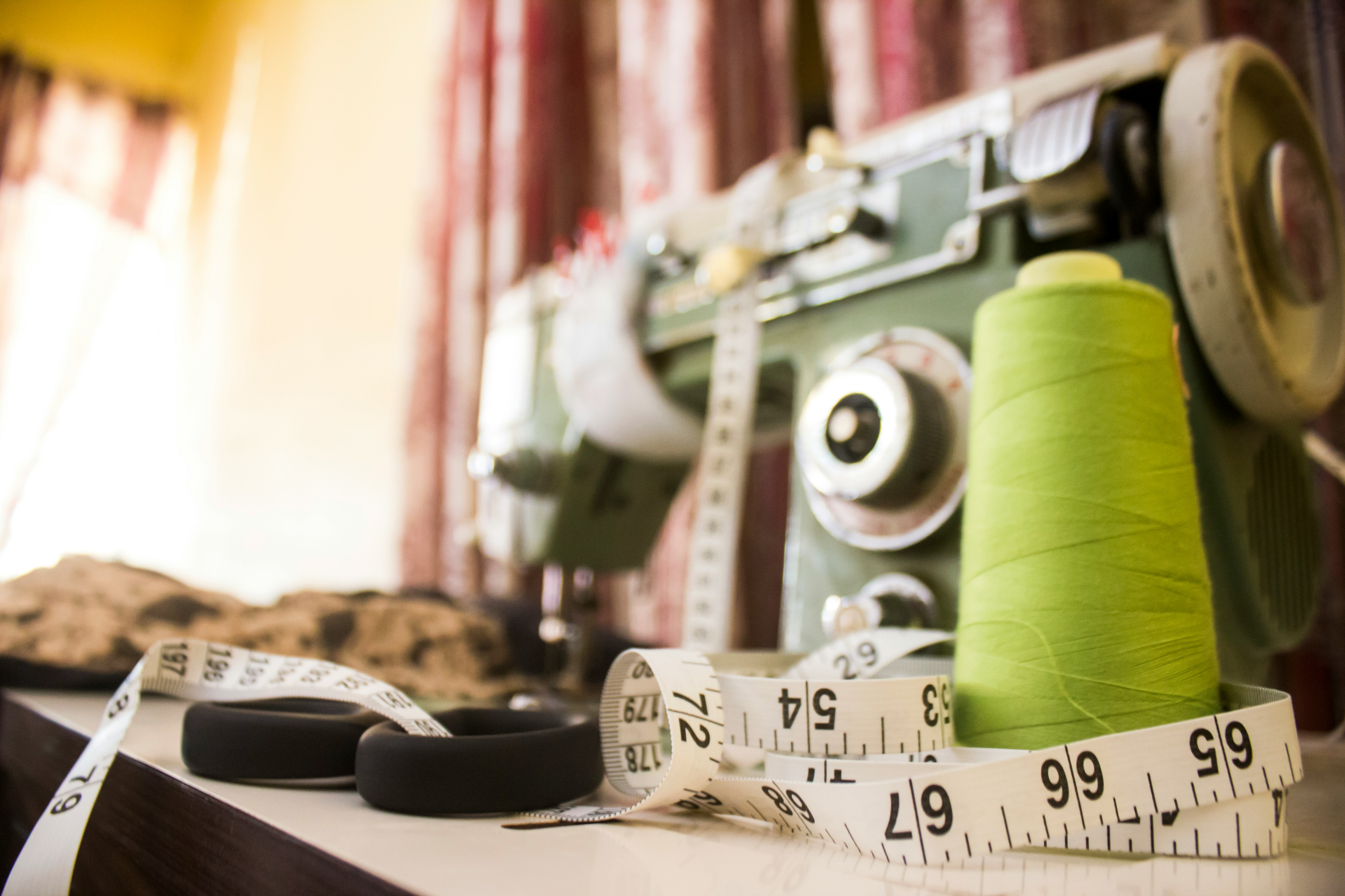 Sewing machine, thread and measuring tape in a tailoring workshop