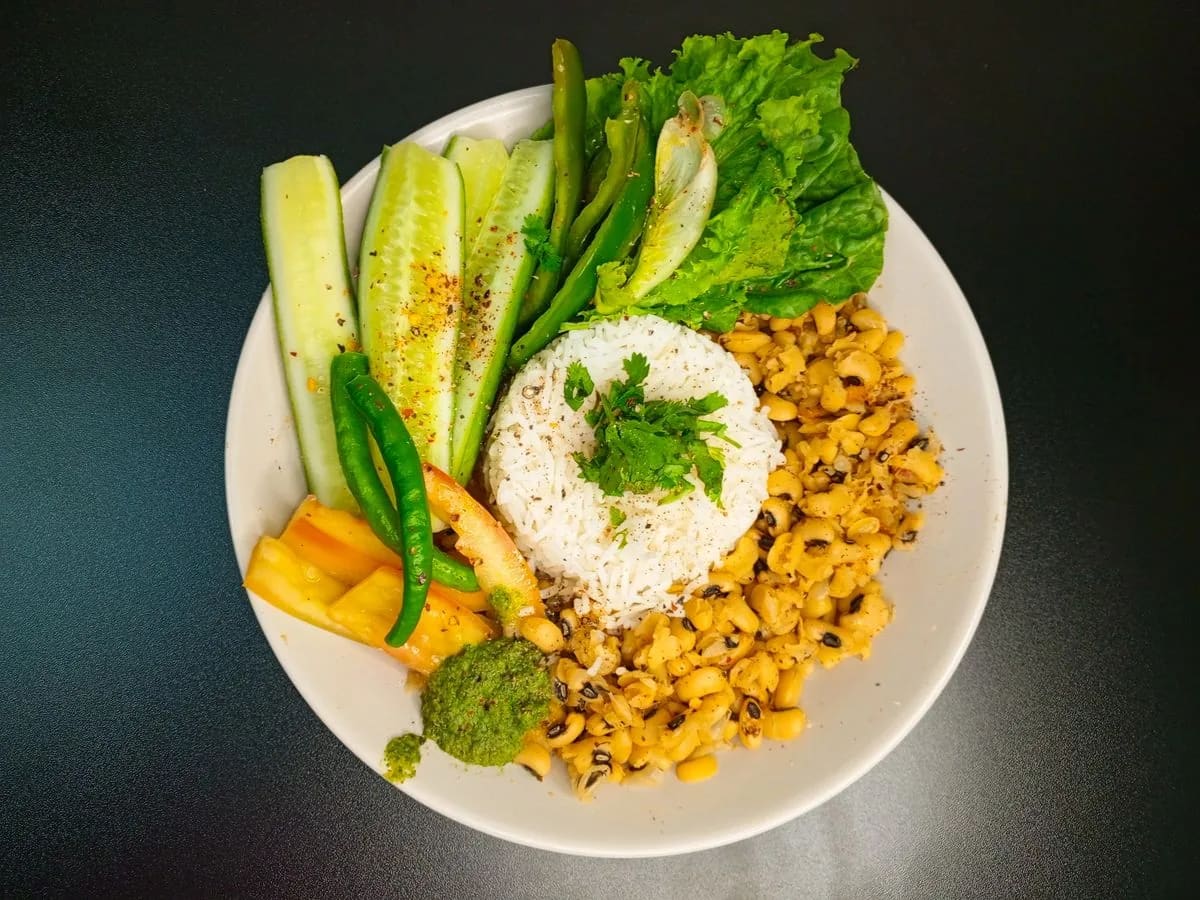 A meal with rice, vegetables, and greens on a plate