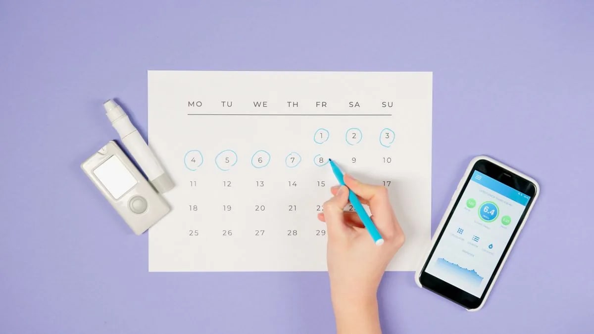 A phone, glucose meter, and calendar used to review daily information