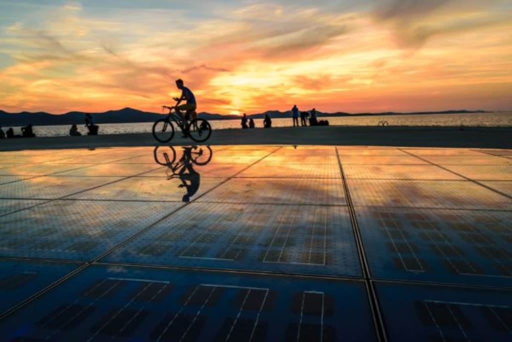 boy biking the greeting to the sun zadar croatia sunset