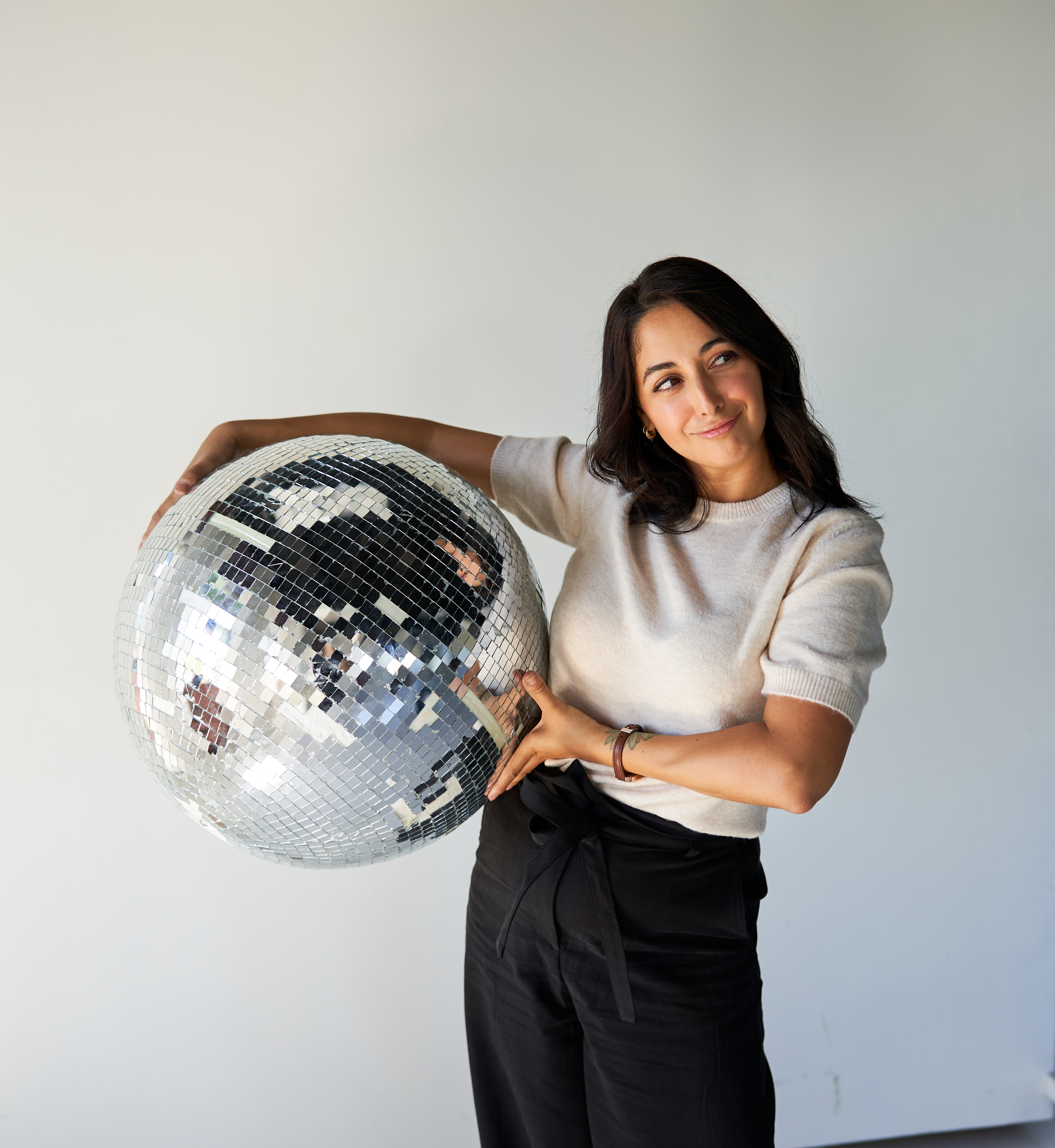 Lauren, founder and strategist of Humming Studio in Gilbert, AZ, holding a disco ball