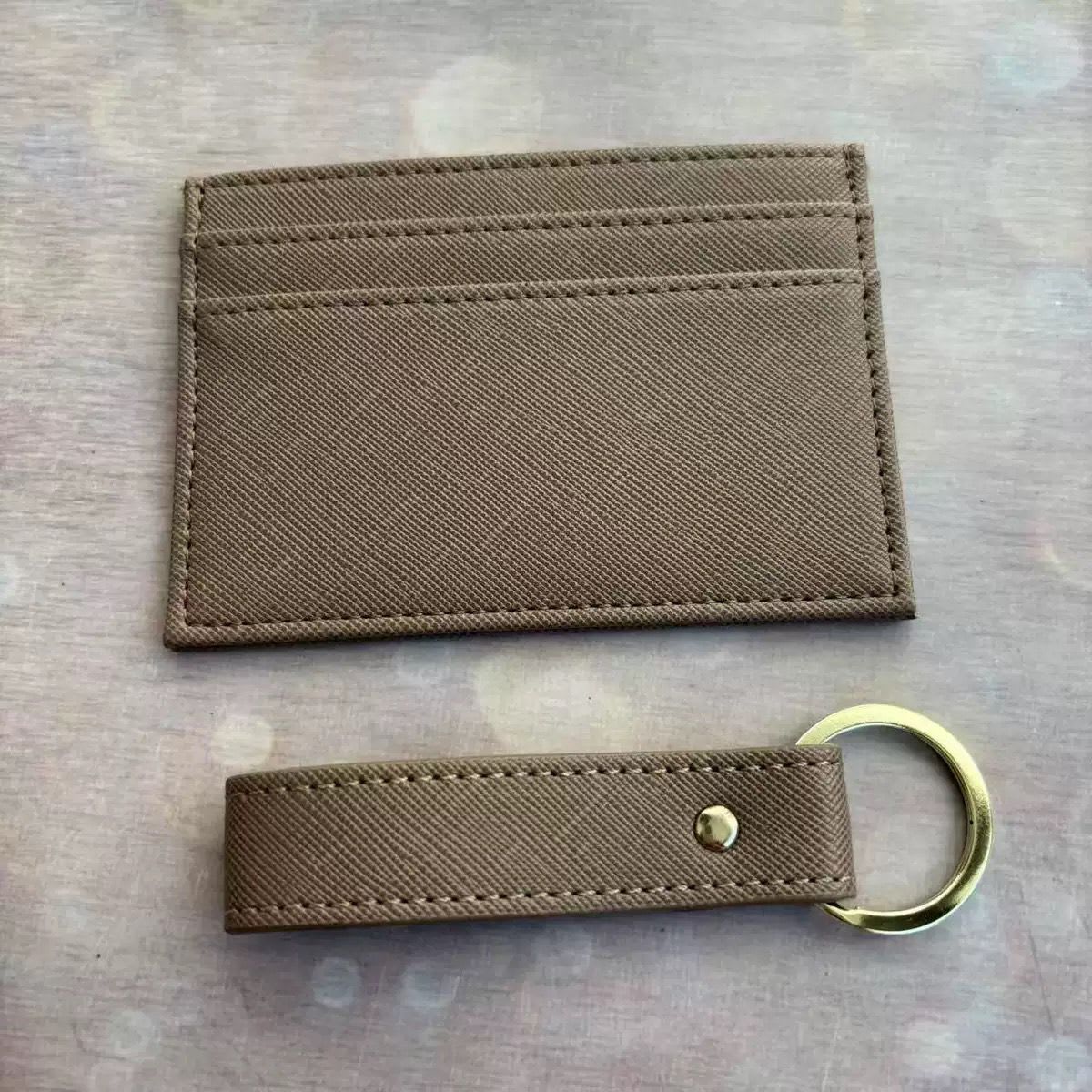 Brown card holder and matching strap keyring on a textured surface