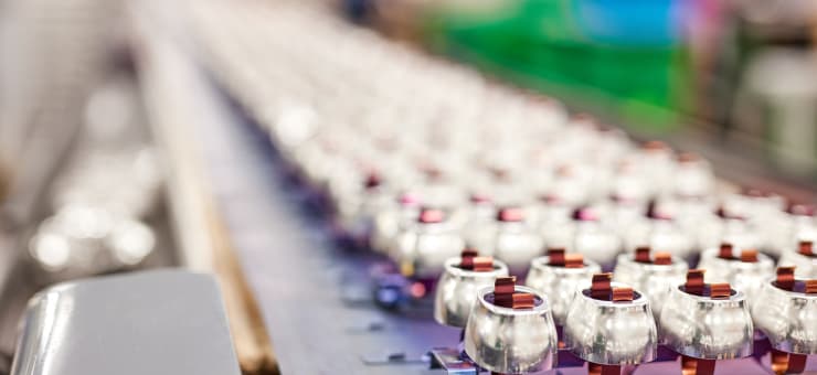 Bright aluminum caps racked on an anodizing line at an Anomatic U.S. factory