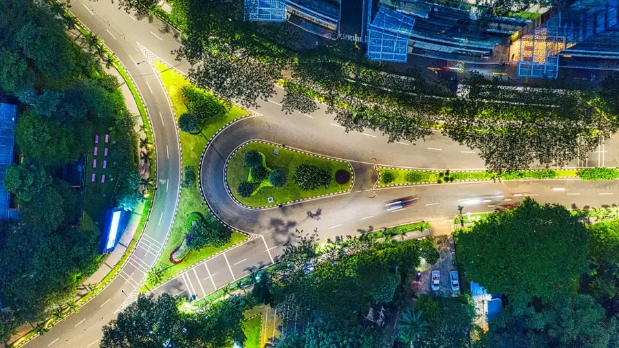 Pemandangan udara yang memukau dari jalanan kota dan gedung yang diterangi di Jakarta, Indonesia pada malam hari.