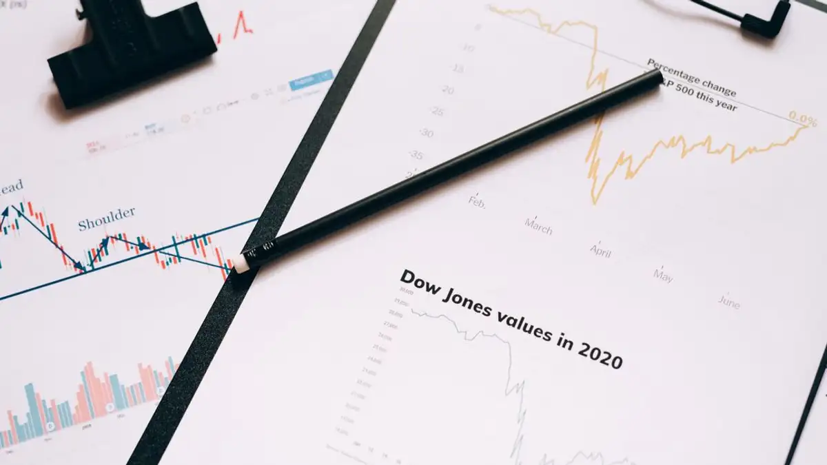 Clipboard dengan grafik dan diagram pasar saham yang mewakili analisis data keuangan.
