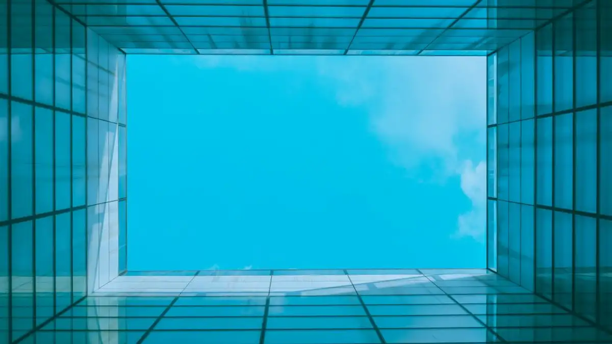 Pemandangan menakjubkan dari langit biru melalui atap arsitektur modern dengan pola geometris.