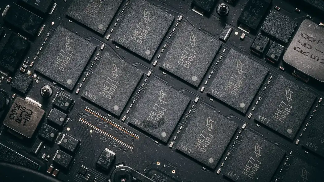 Tampilan detail komponen papan sirkuit elektronik yang memperlihatkan mikrochip dan seluk-beluk teknologinya.