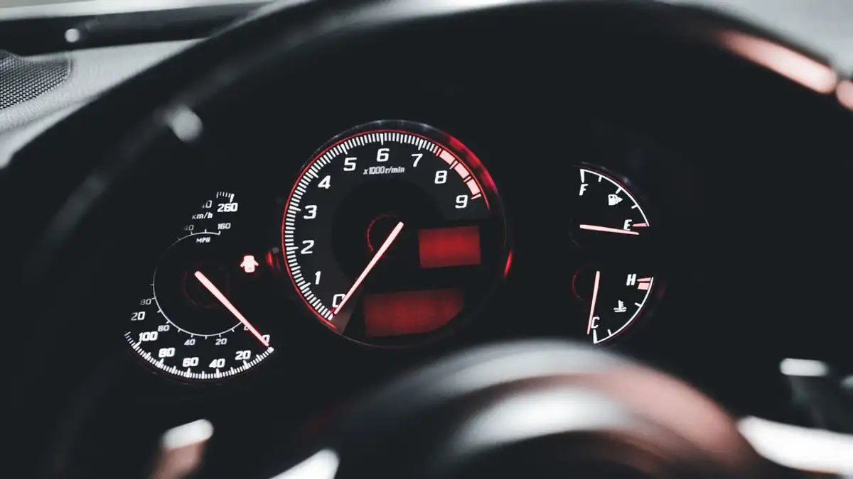 Tampilan terperinci dari dashboard mobil modern dengan speedometer dan indikator yang menyala.