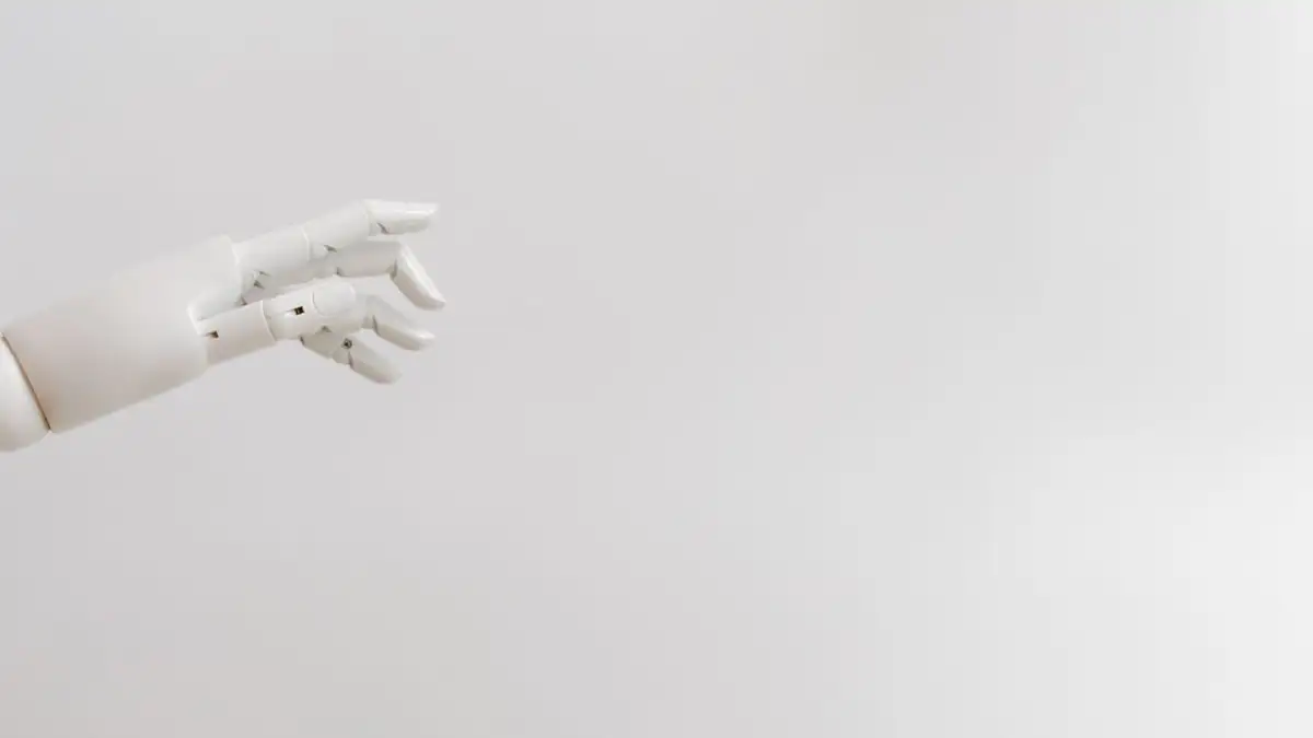 Gambar minimalis dari tangan robot yang menjulur di latar belakang putih.