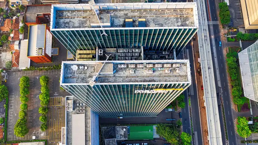 Pemandangan udara dramatis dari gedung pencakar langit modern di Jakarta Selatan, Indonesia yang menampilkan arsitektur perkotaan.
