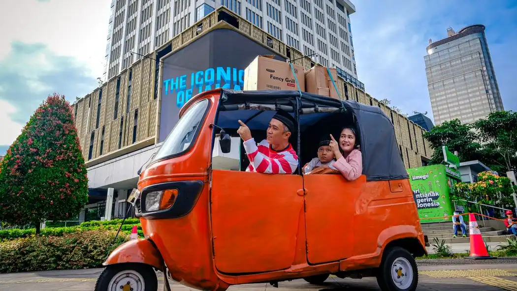 Sebuah keluarga menikmati tur keliling kota Jakarta yang ramai, diabadikan dalam tuk tuk warna-warni.