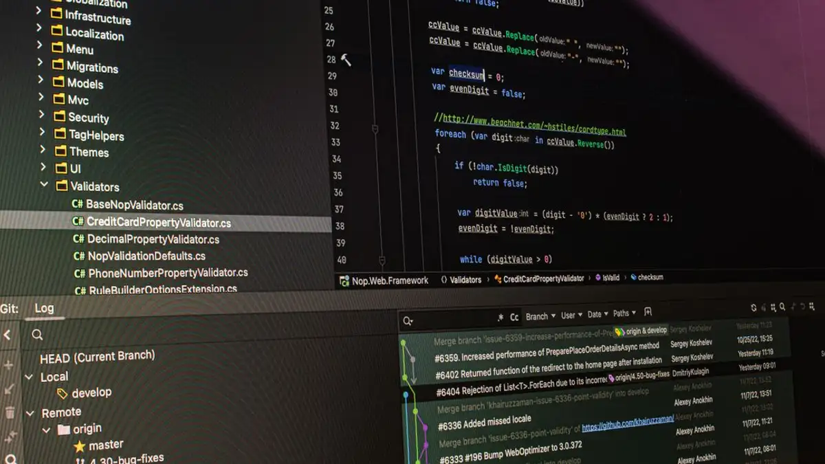 Close-up alat pengembangan perangkat lunak yang menampilkan kode dan sistem kontrol versi di monitor komputer.