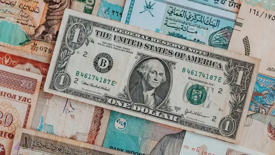 Close-up berbagai uang kertas internasional yang menciptakan latar belakang mata uang yang beragam.