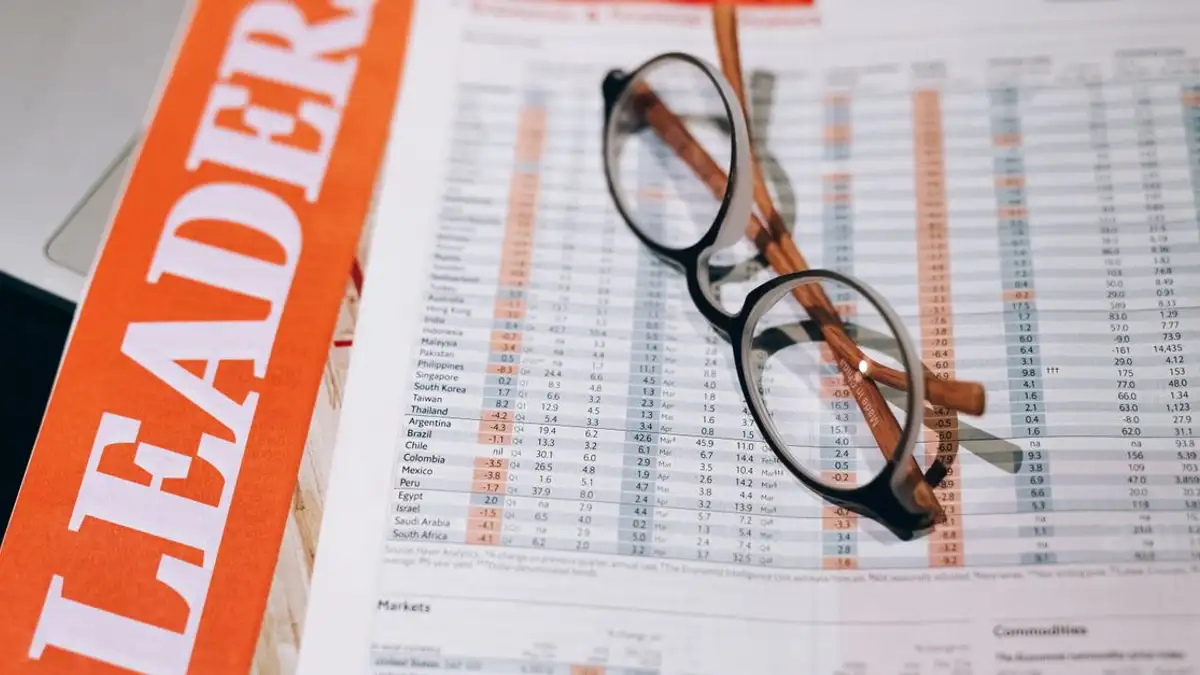 Kedekatan dokumen keuangan dengan kacamata, menggambarkan analisis data dan wawasan bisnis.