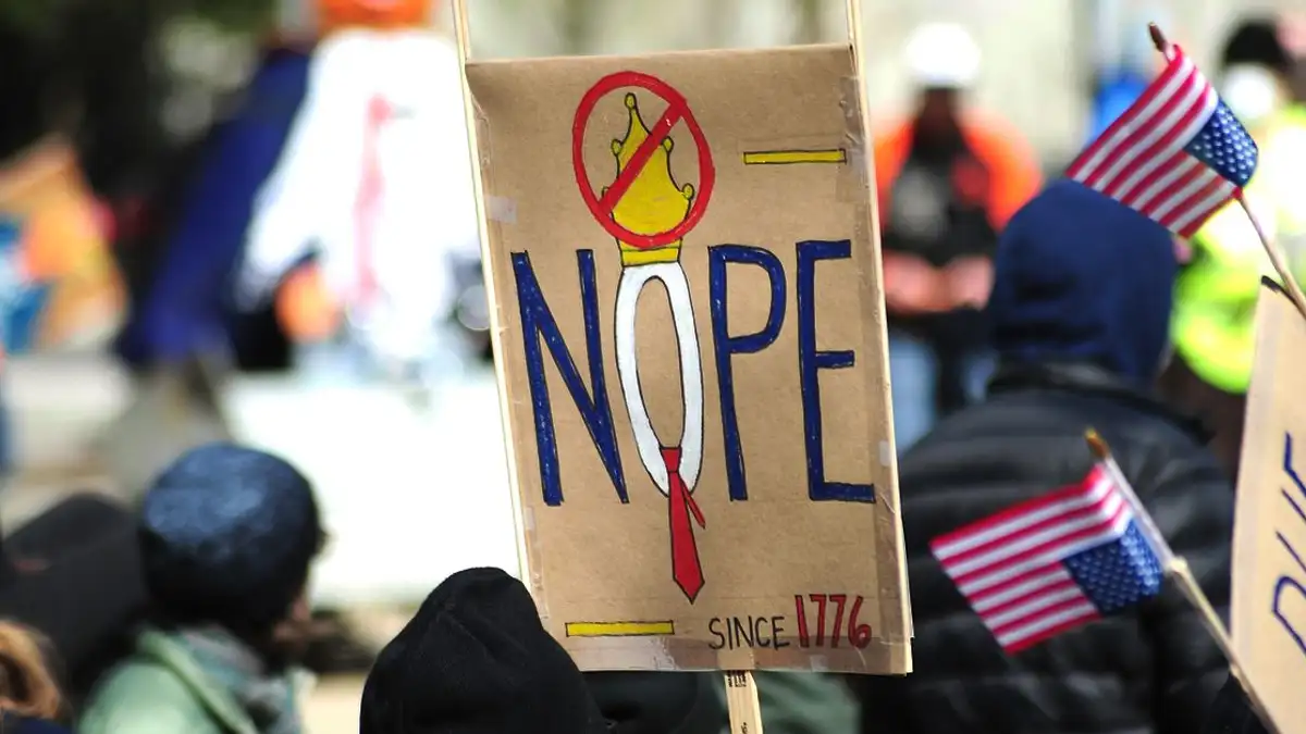 Para peserta memegang tanda-tanda anti-monarki dalam sebuah protes di Baltimore, AS, untuk mengekspresikan sentimen politik mereka.