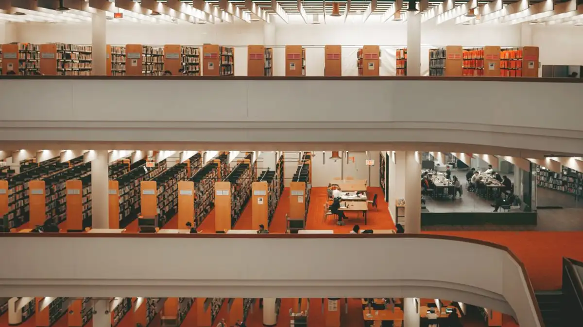 Tampilan interior perpustakaan modern bertingkat di Toronto, memamerkan rak buku dan area baca.