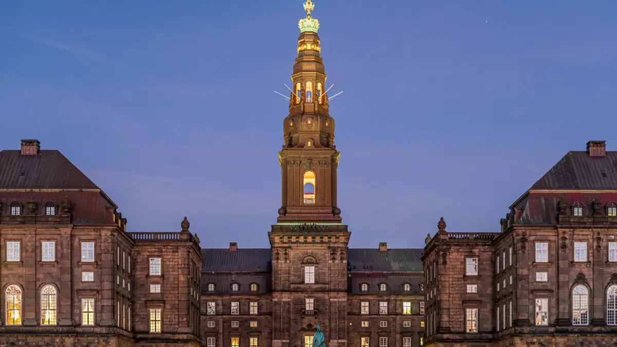 Istana Christiansborg yang diterangi di Kopenhagen saat senja memperlihatkan arsitektur historisnya.