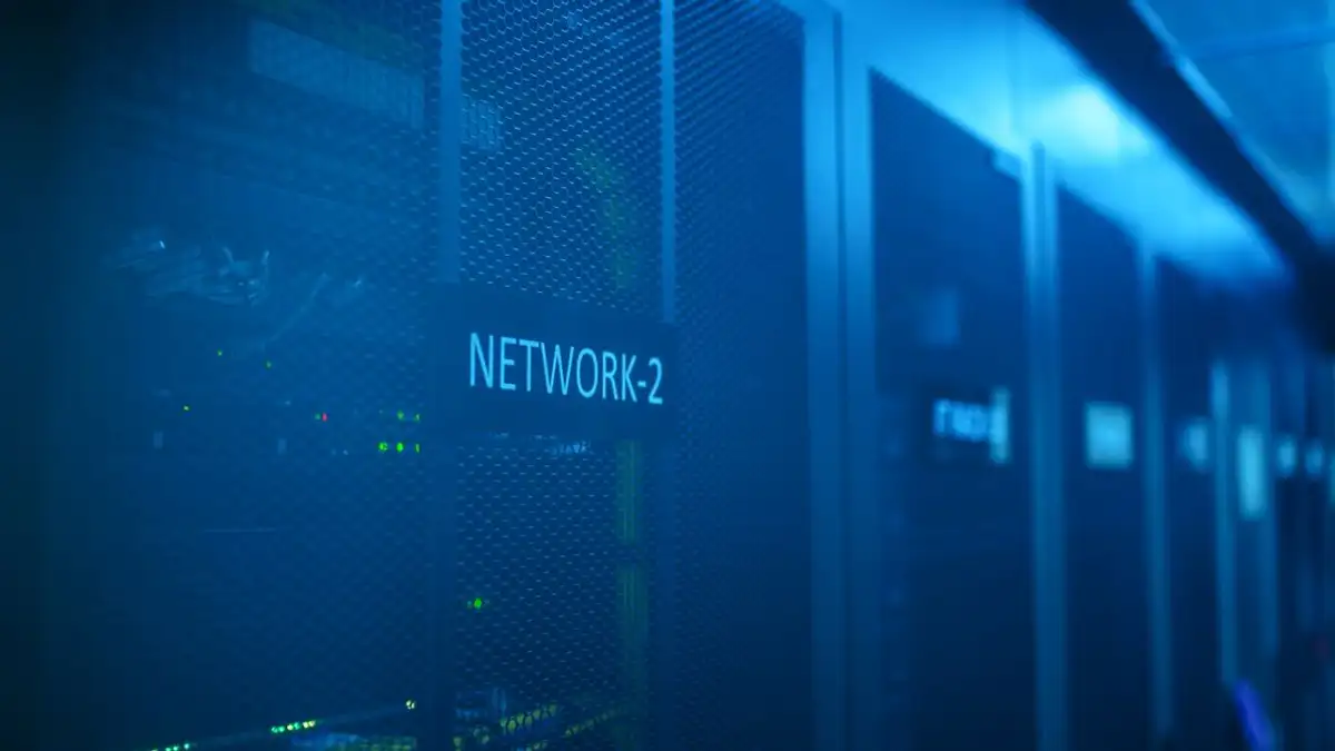Ruang server modern yang menampilkan peralatan jaringan dengan iluminasi biru. Ideal untuk tema teknologi.