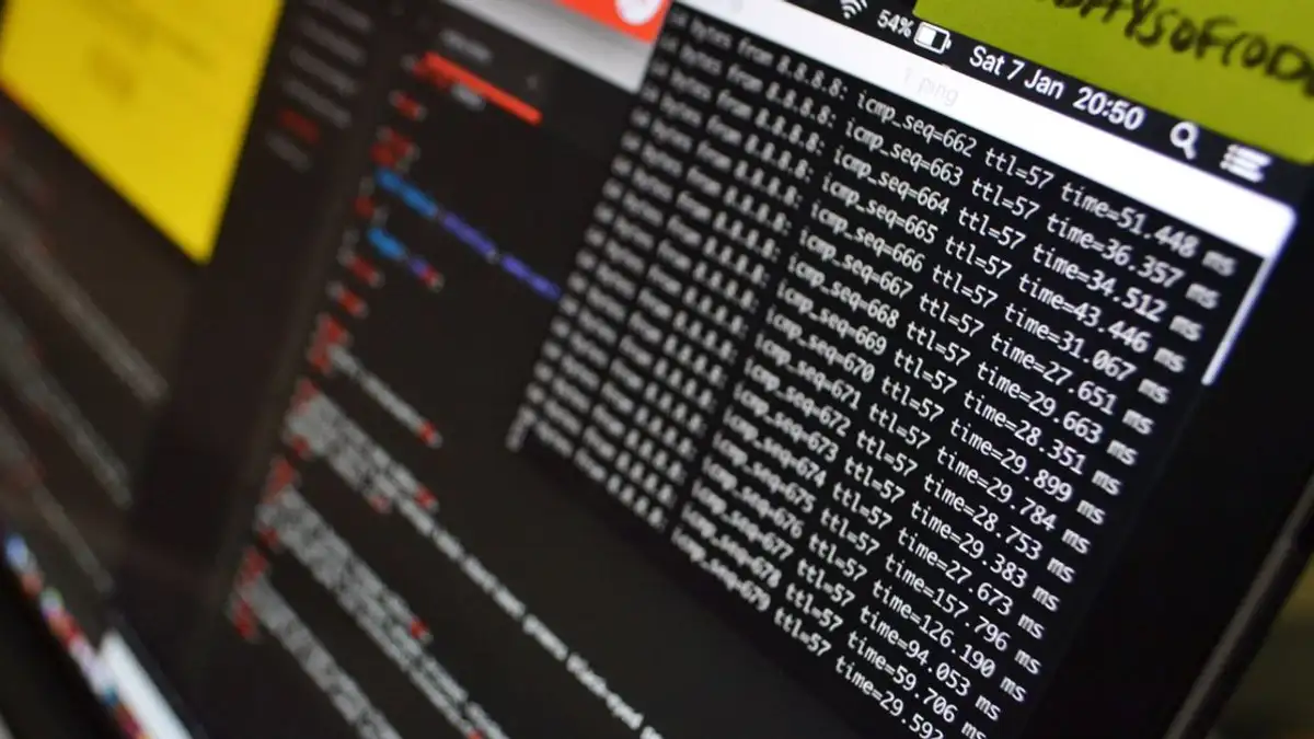 Kutipan makro dari laptop dengan tampilan kode dan analisis data yang sedang berlangsung. Cocok untuk tema teknologi.