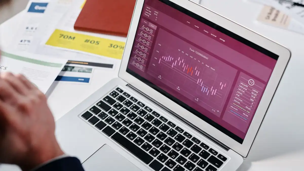 Pejabat yang meninjau analisis data di layar laptop di lingkungan kantor.