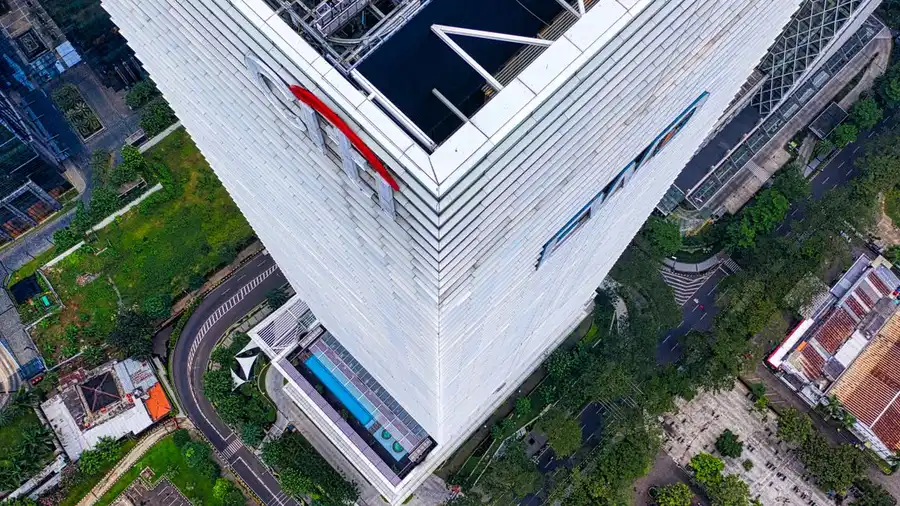 Tangkapan udara sudut tinggi dari gedung pencakar langit di Jakarta, Indonesia yang menampilkan arsitektur modern.