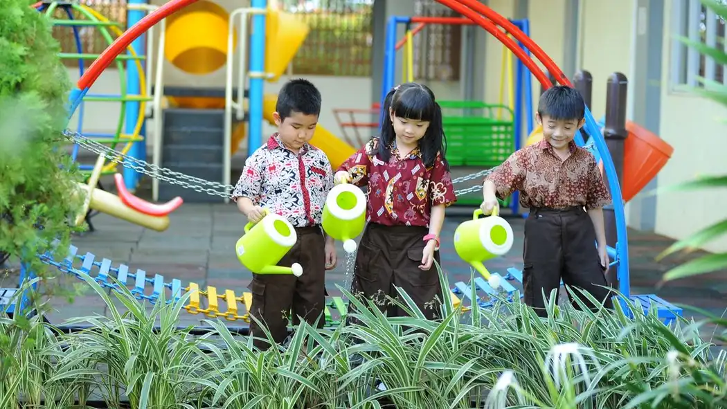 Sekelompok anak-anak menikmati berkebun di area bermain.