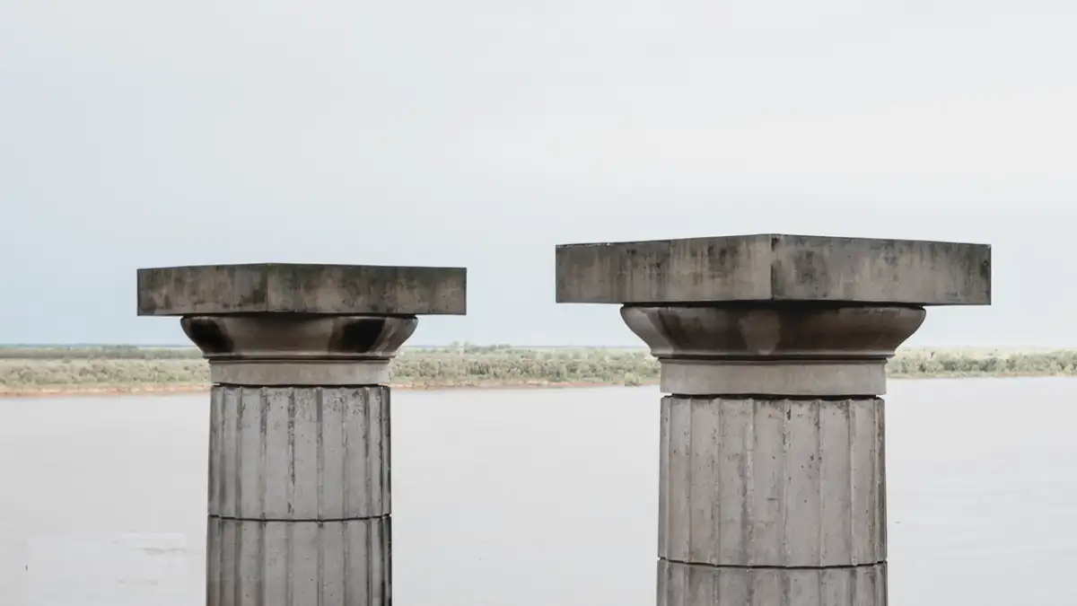 Pilar-pilar beton elegan yang menghadap ke Sungai Parana dengan latar belakang lanskap yang tenang di Rosario, Argentina.
