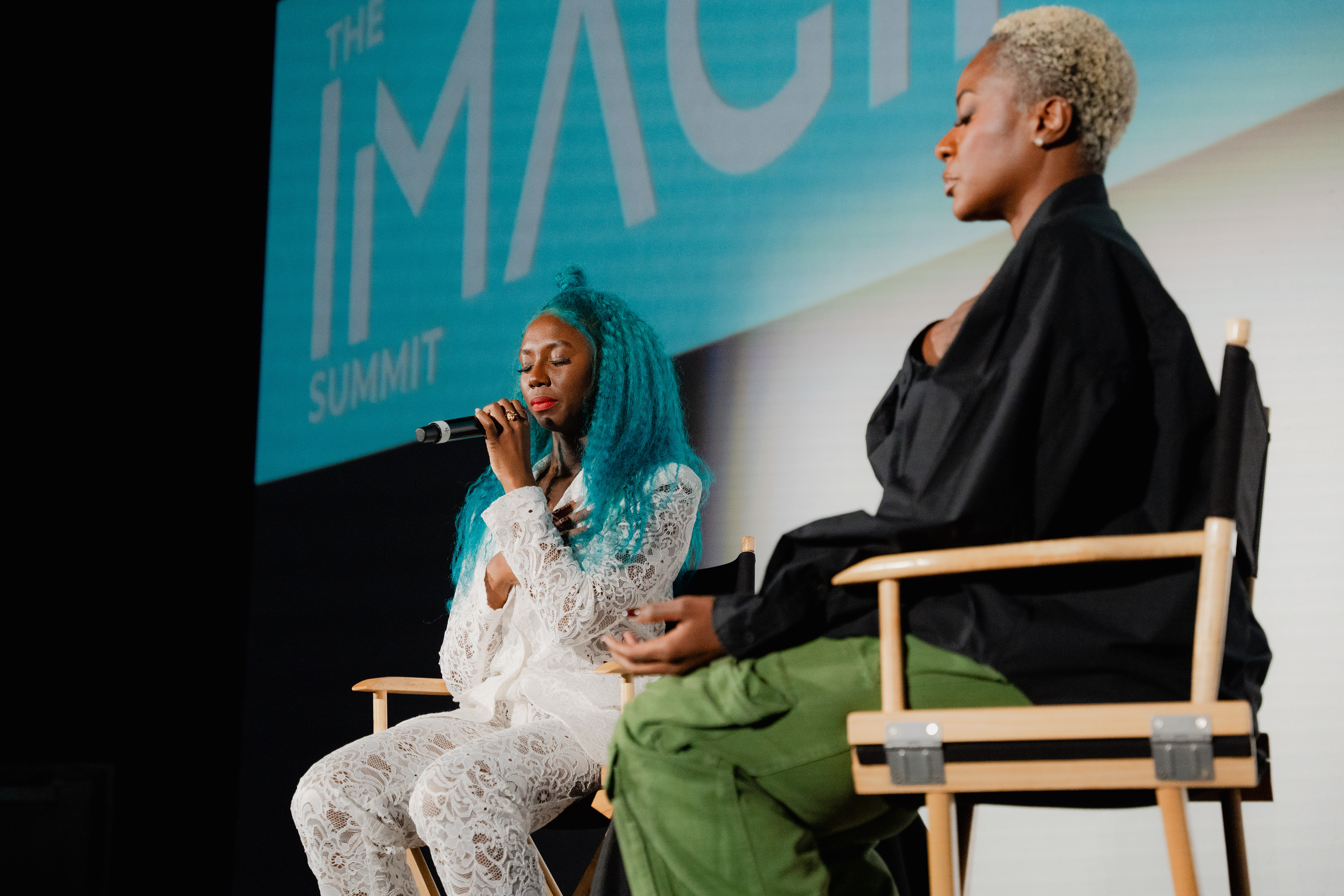 Panel discussion on stage at Imagiin Summit with speakers in conversation.
