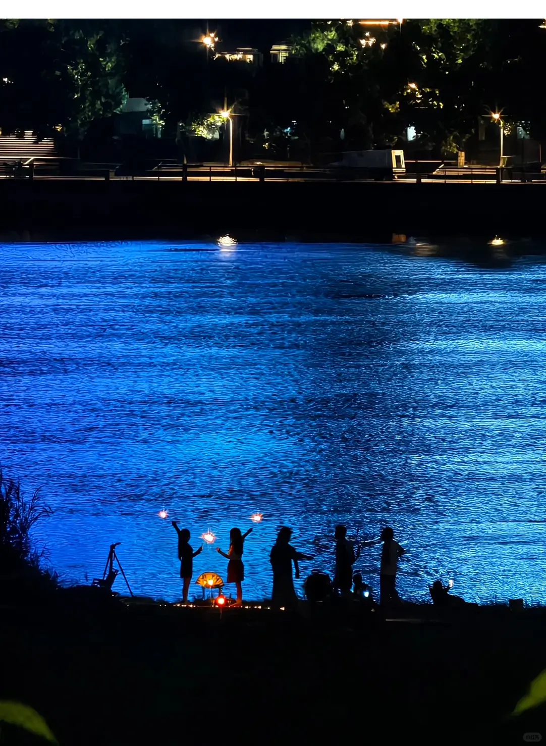 Friends beside blue water
