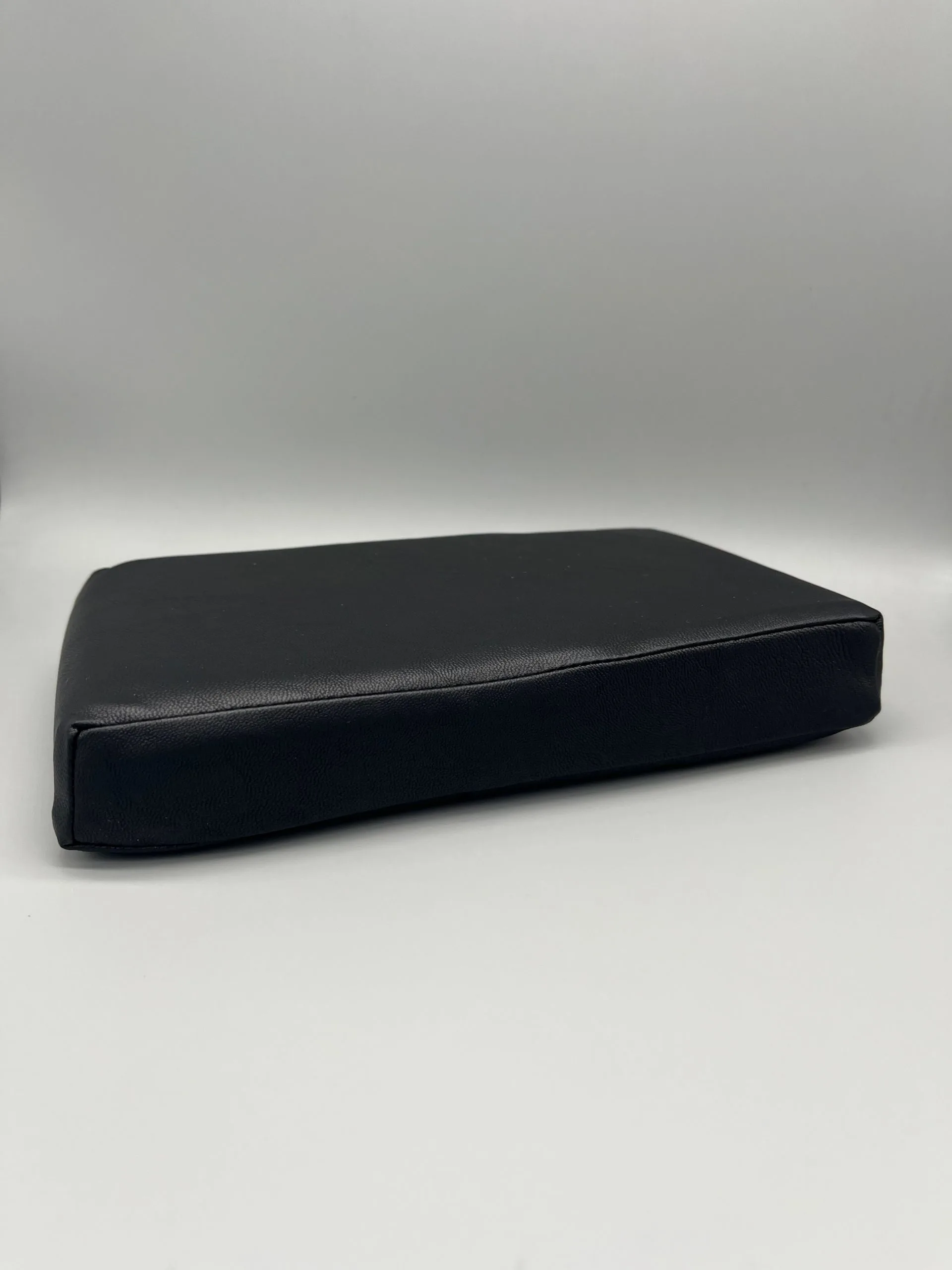 Black vinyl-covered Scoli-Flat wedge shown from the side, a low-profile Scolio-Pilates wedge